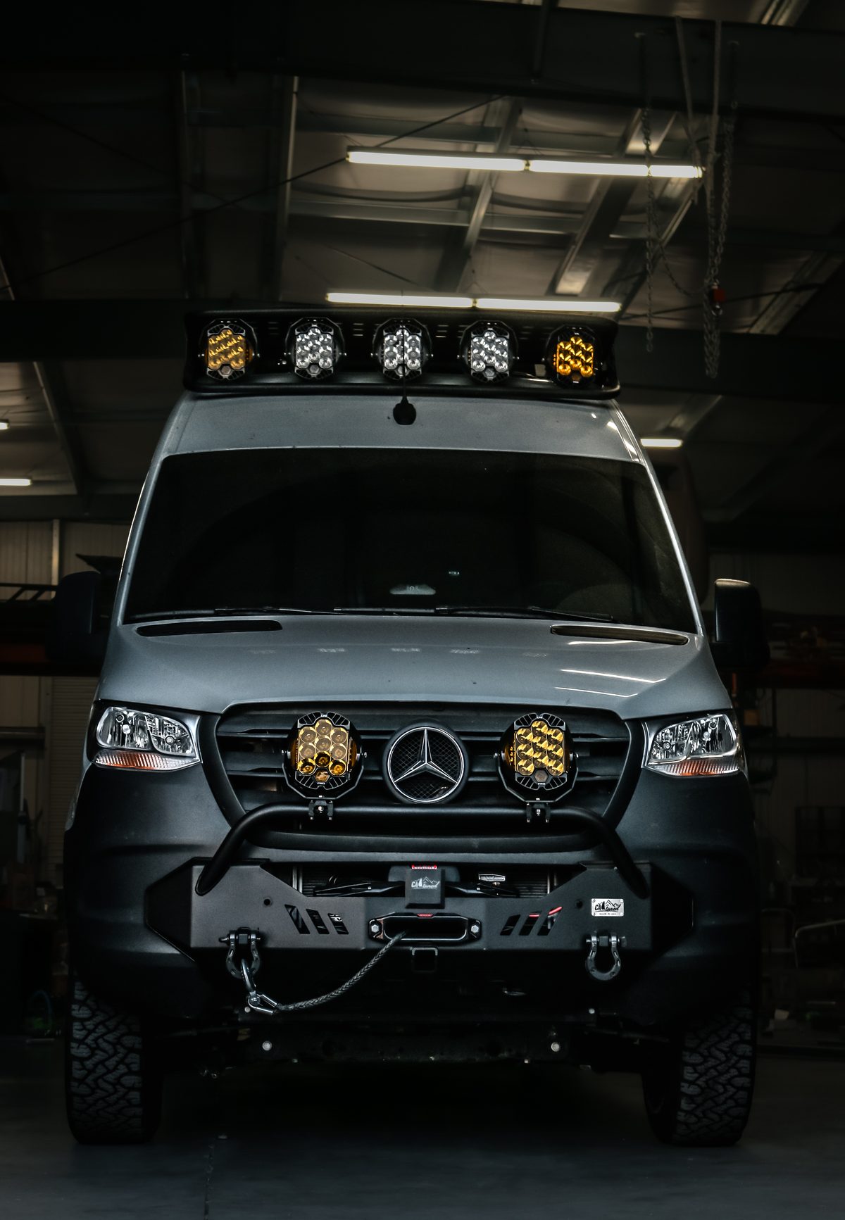 Front view of a Mercedes Sprinter 170 extended with a Rugged Design Concepts Baja LP:9 roof rack and a CAtuned front bumper with winch