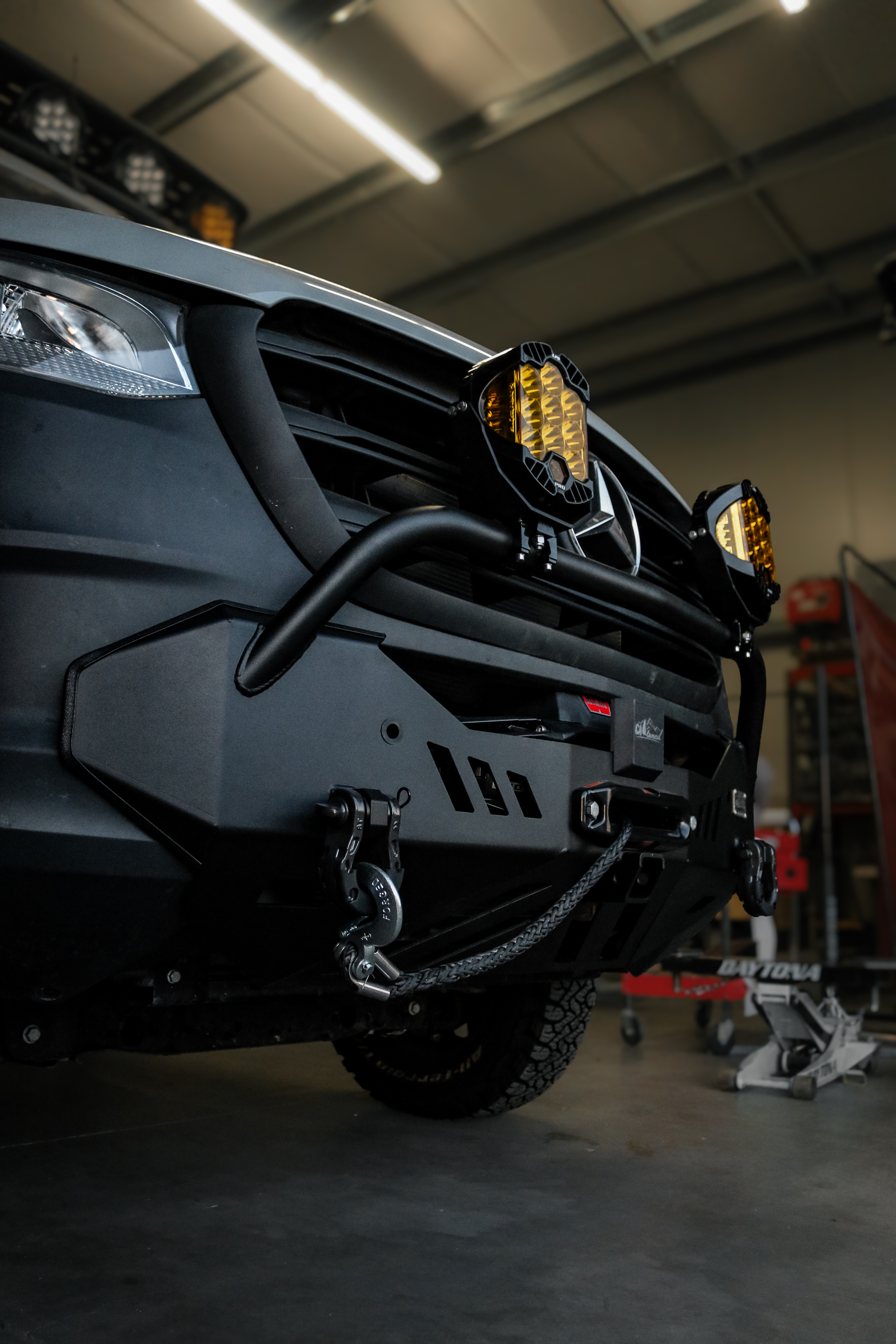 Side angle of the CAtuned Sprinter front bumper showing the tubular bull bar, grey shackle D-rings and synthetic winch line